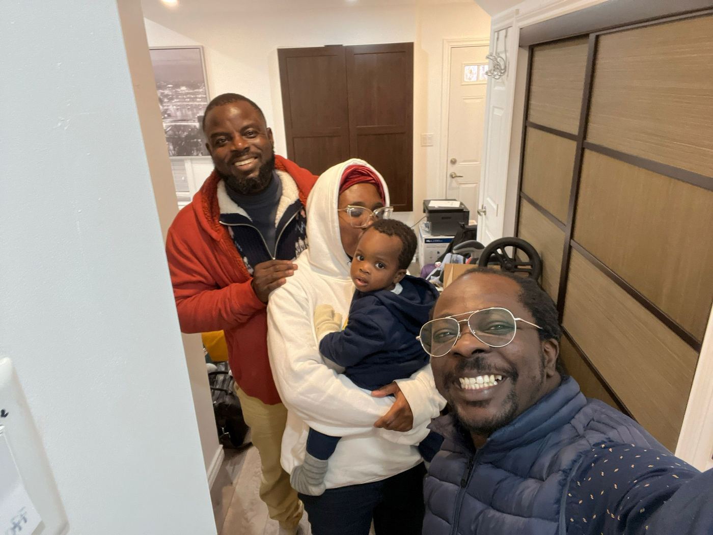 Ayoola Gbade-Bello and family with a friend at their temporary accommodation, first days in Canada