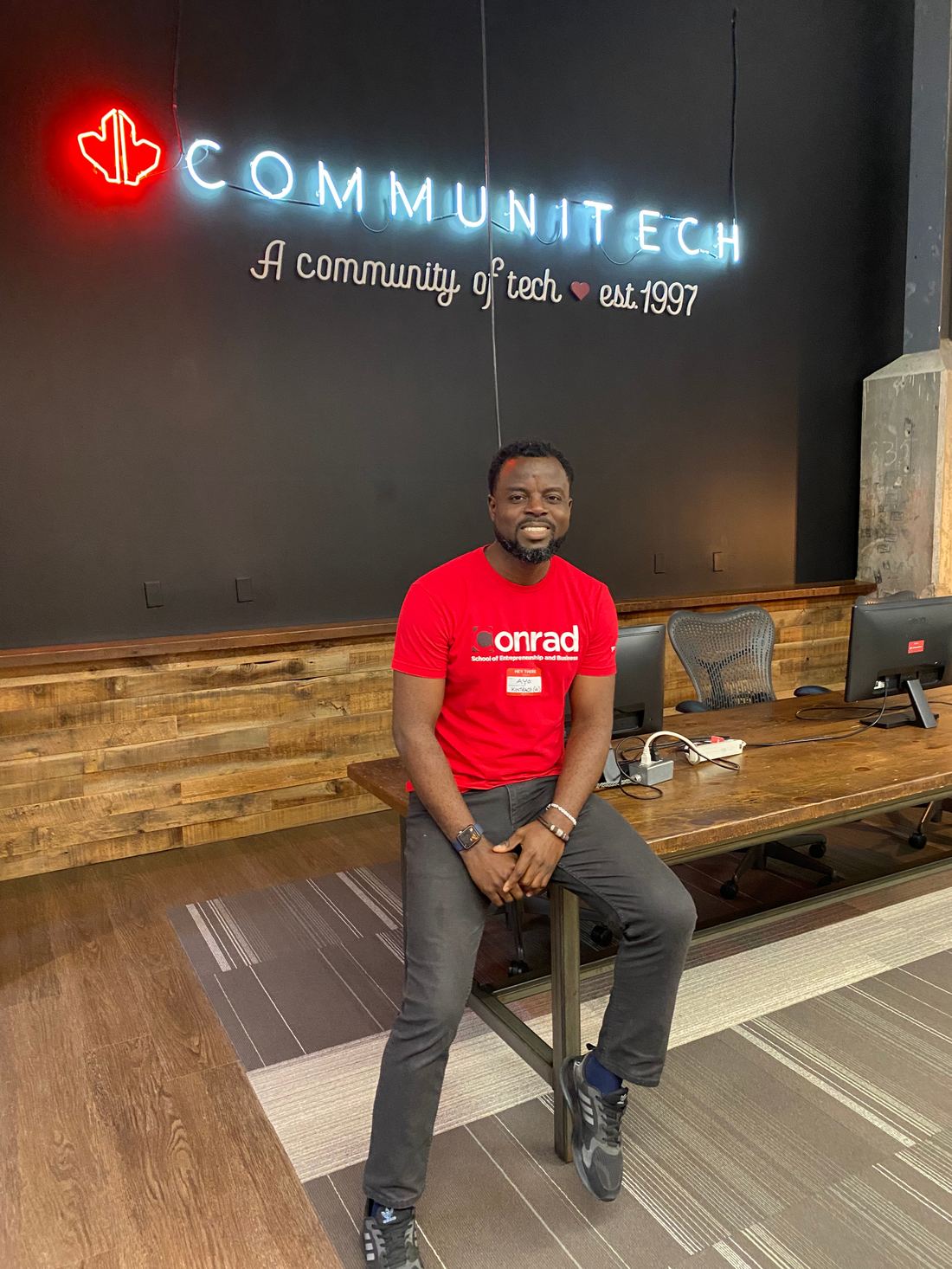 Ayoola Gbade-Bello at Communitech, wearing a Conrad School of Entrepreneurship and Business shirt